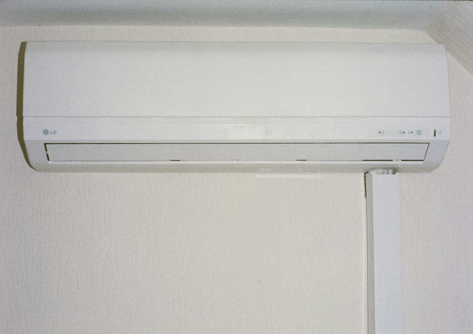 White wall-mounted split air conditioning indoor unit installed above a doorway