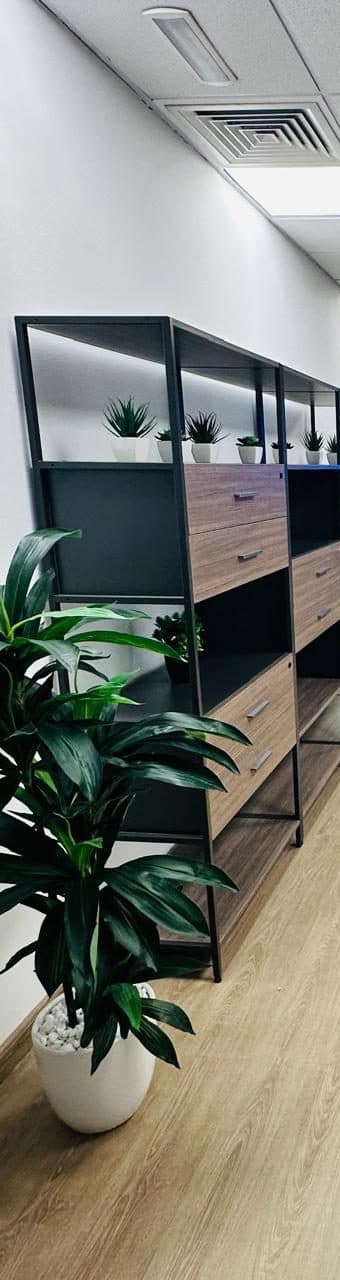 Black metal-frame shelving with wood-toned drawers, built and styled as part of an office joinery fit-out.