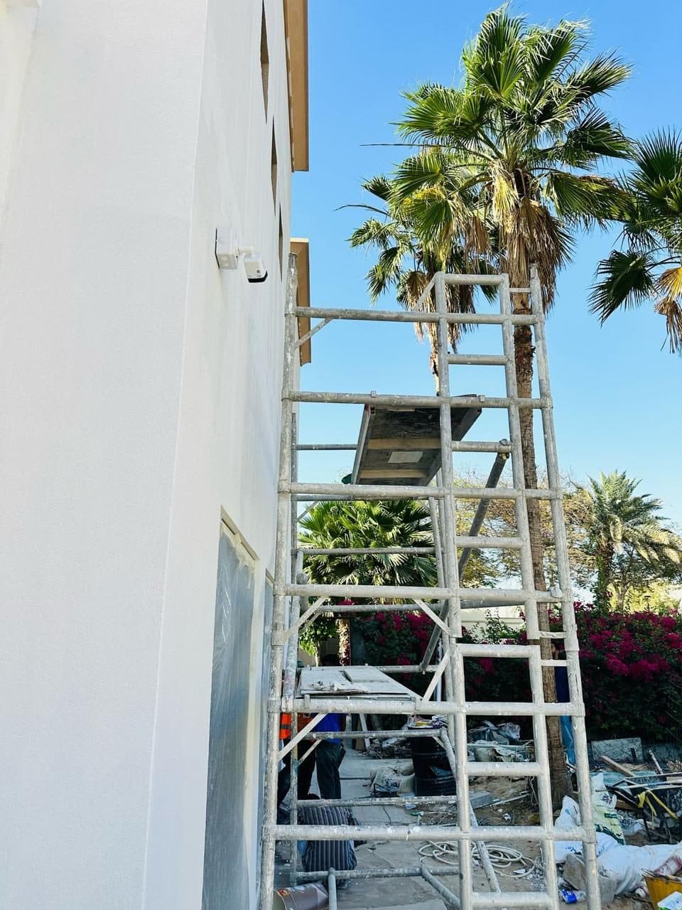CCTV camera mounted on an exterior building wall alongside scaffolding, installed as part of a wider site fit-out.