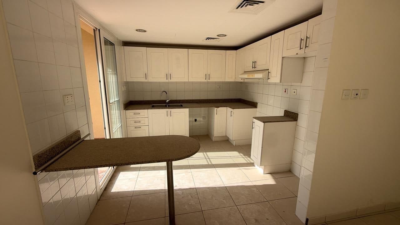 An existing shaker-style kitchen with tiled walls and floor, photographed ahead of a planned renovation.